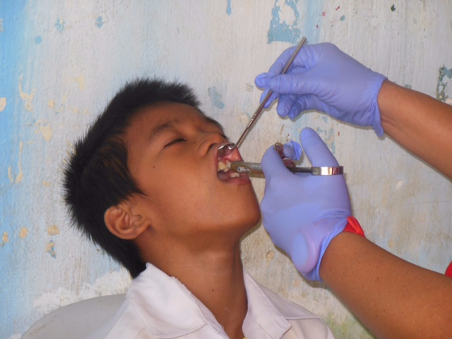 Nurse checking the teeth of a young patient